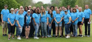 YOC staff members pose at the 2019 Golf Outing, smiling at the camera.